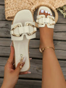 Sandálias rasas para mulher com detalhes em metal – um look elegante e confortável para o verão europeu.